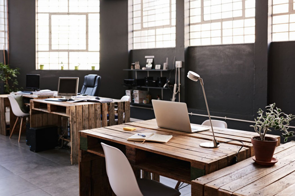 modern office workspace with pallet desks and laptops