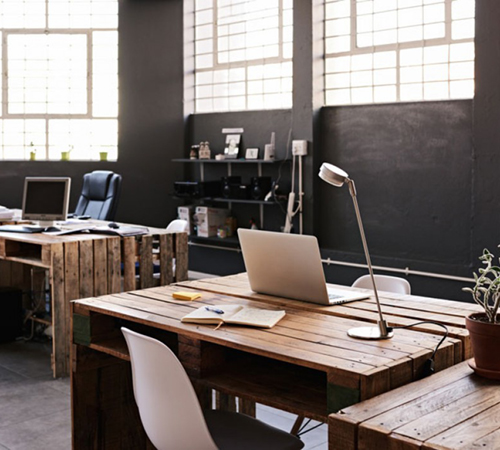 modern office workspace with pallet desks and laptops